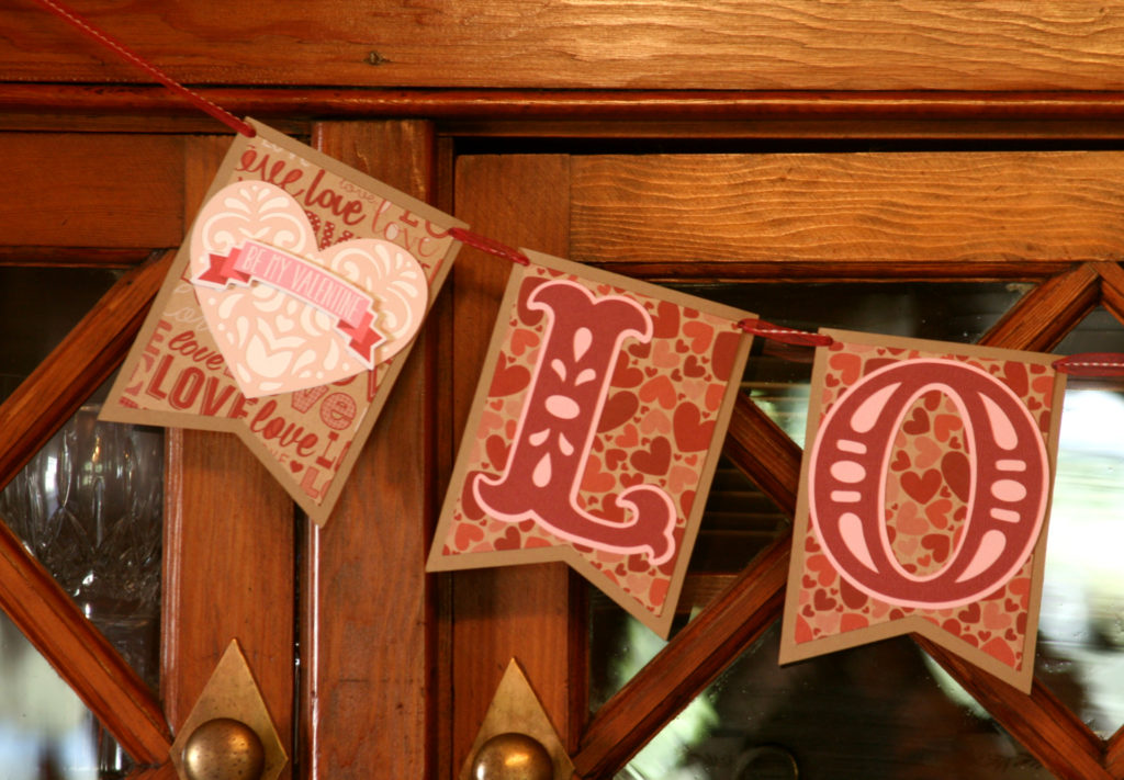 Celebrate Valentine’s Day by making this easy DIY love garland. Simple, festive decor for your next Valentine or Galentine party. #craftedliving #valentinesday #galentine #diycrafts