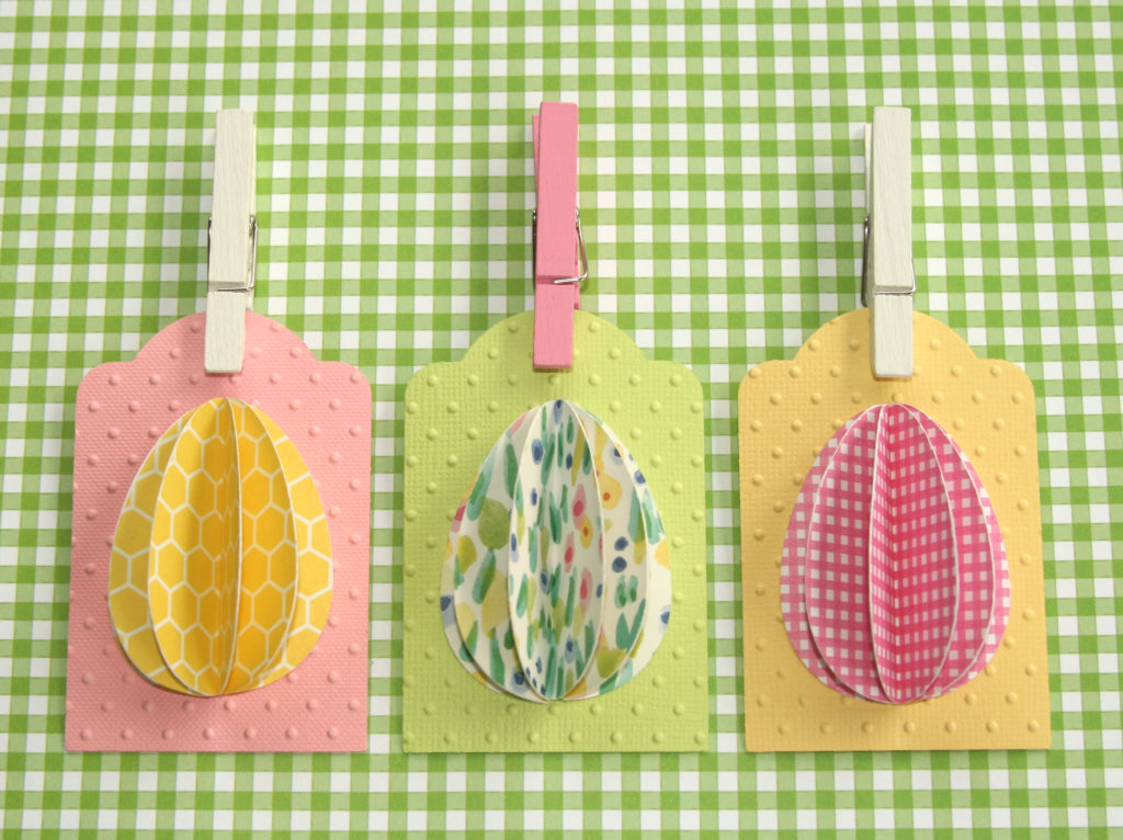 Celebrate Easter by making these simple DIY egg tags using your favorite paper. Fun idea to add to your Easter baskets or treats to make them extra special. #craftedliving #easter #easterdiy #diycrafts