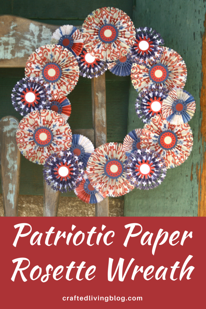Make a beautiful DIY Patriotic Paper Rosette Wreath to hang on your door. Perfect for Memorial Day or the 4th of July or any patriotic celebration. Simply follow this step by step tutorial. #craftedliving #diycrafts #wreaths #wreathtutorial
